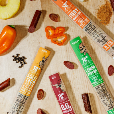 RF meat sticks on wooden background with ingredients